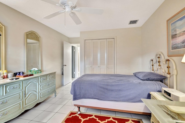 tiled bedroom with ceiling fan and a closet