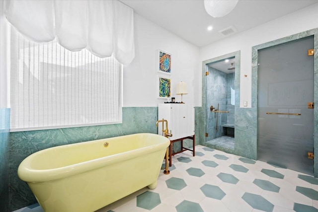 bathroom featuring separate shower and tub and tile walls