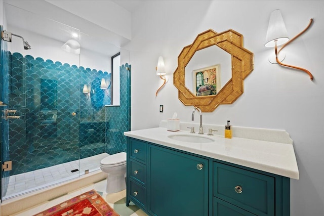 bathroom with tiled shower, vanity, and toilet