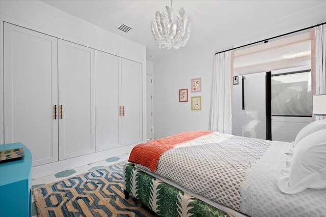 bedroom with an inviting chandelier and a closet