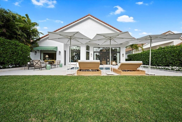 rear view of property with an outdoor living space, a yard, and a patio