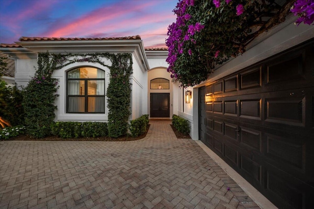 exterior entry at dusk with a garage