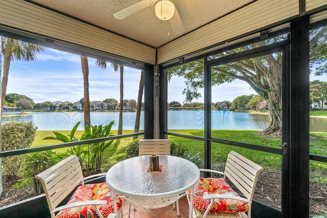 sunroom featuring a water view and ceiling fan