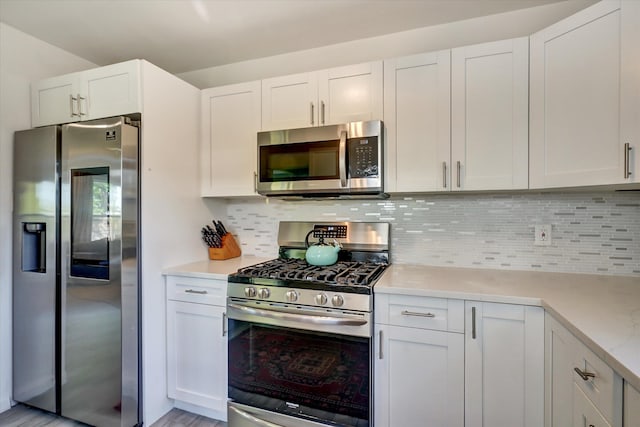 kitchen featuring white cabinetry, stainless steel appliances, and backsplash