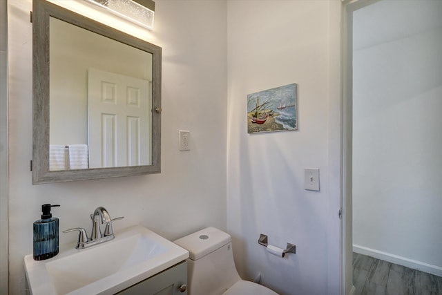 bathroom with vanity, hardwood / wood-style flooring, and toilet