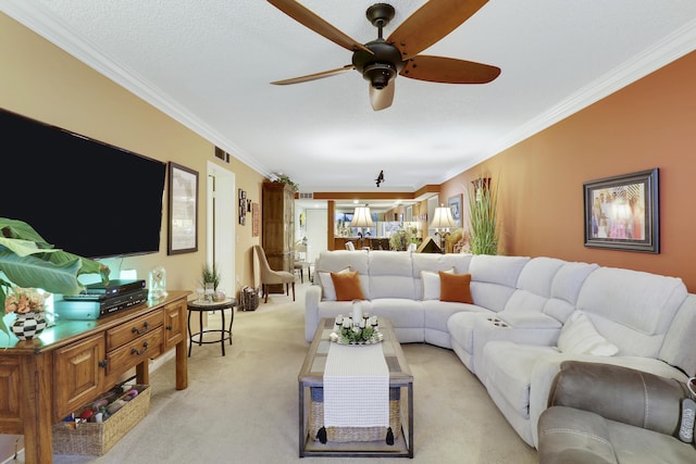 living room featuring crown molding, light colored carpet, ceiling fan, and a textured ceiling