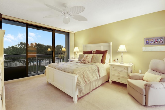 bedroom featuring access to outside, light colored carpet, ceiling fan, and a wall of windows