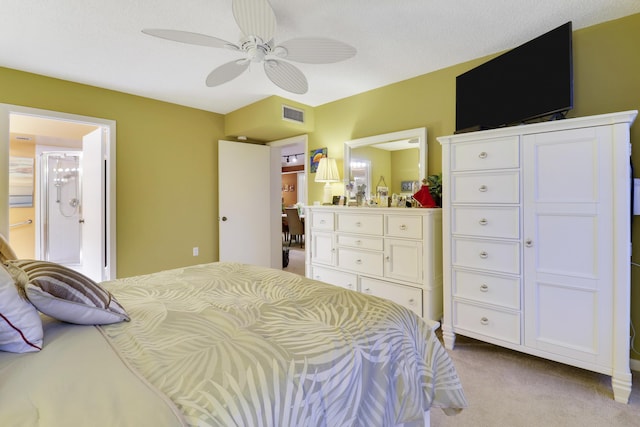 carpeted bedroom with ceiling fan and ensuite bath