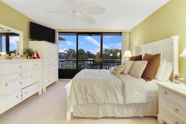 carpeted bedroom featuring floor to ceiling windows, access to outside, and ceiling fan