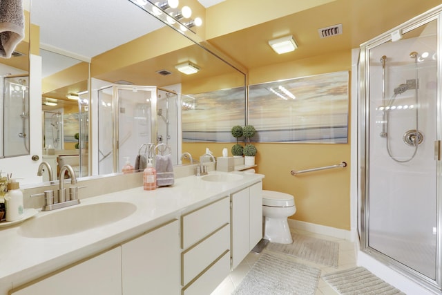 bathroom featuring tile patterned flooring, vanity, a shower with shower door, and toilet