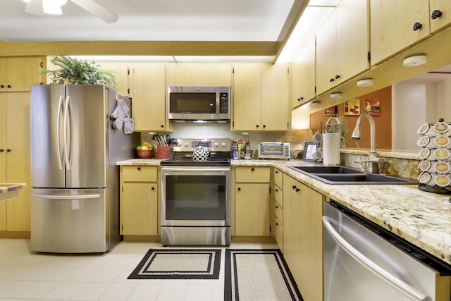 kitchen with light brown cabinetry, sink, and appliances with stainless steel finishes