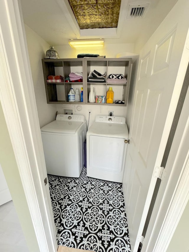 laundry room with washer and dryer and light tile patterned floors