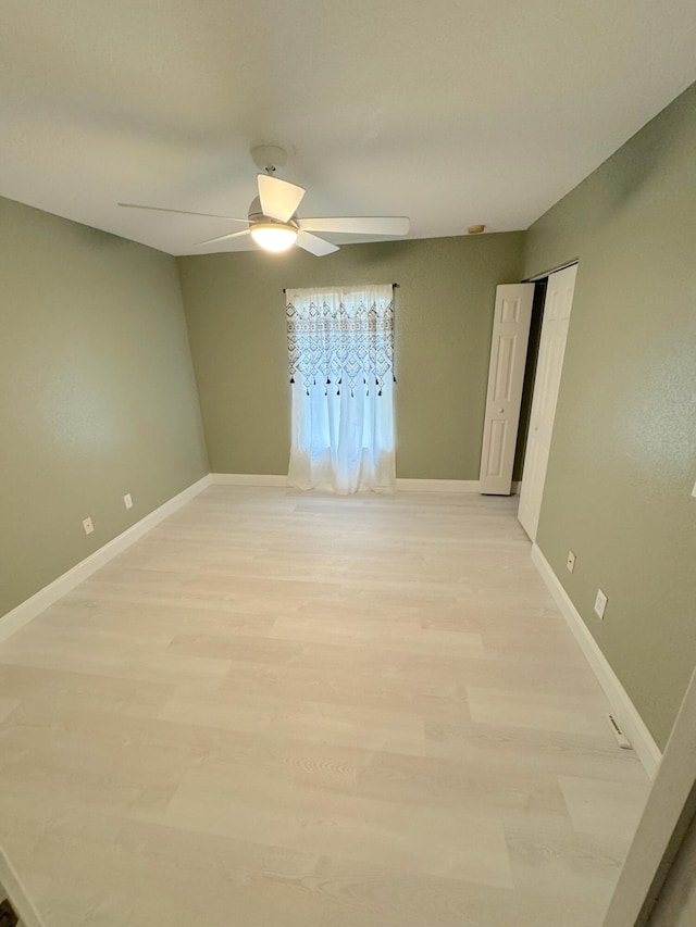 empty room with light hardwood / wood-style flooring and ceiling fan