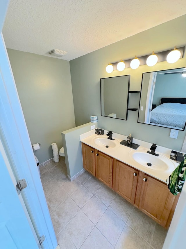 bathroom with vanity, tile patterned flooring, toilet, and a textured ceiling