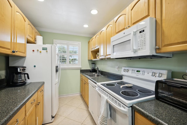 kitchen featuring dark countertops, ornamental molding, light tile patterned flooring, white appliances, and a sink