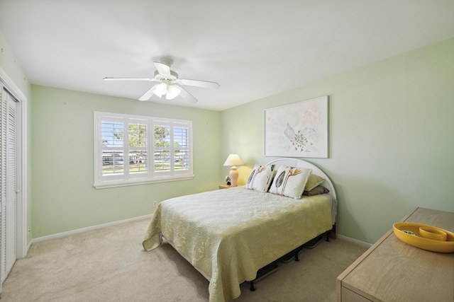 carpeted bedroom with ceiling fan and a closet