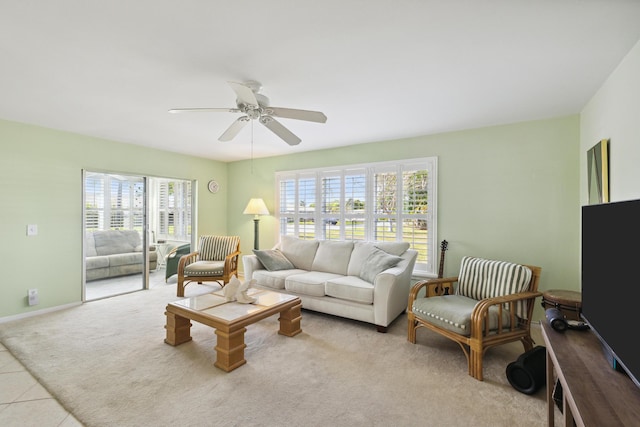 carpeted living room featuring tile patterned floors, baseboards, and a ceiling fan