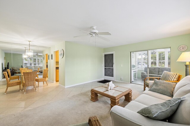 living room featuring ceiling fan with notable chandelier and light tile patterned flooring