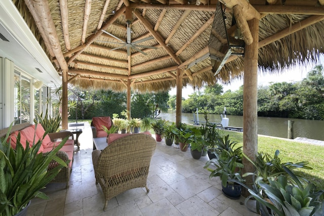 view of patio with a gazebo, a water view, and ceiling fan