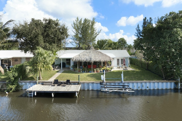 view of dock with a lawn and a water view