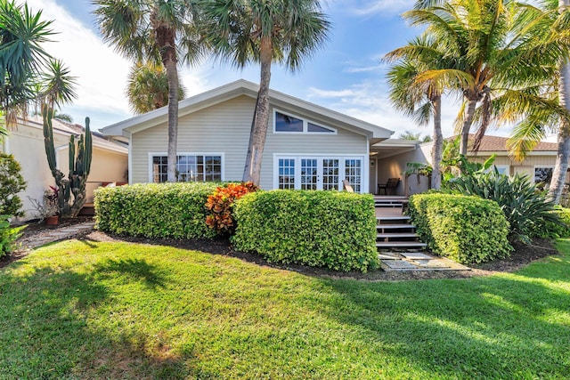 back of property with a wooden deck and a lawn