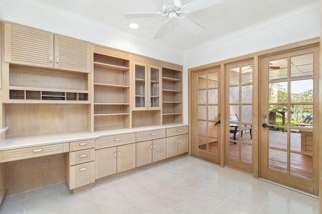 unfurnished office featuring crown molding, ceiling fan, built in desk, a textured ceiling, and french doors