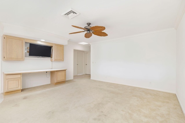 unfurnished living room with light carpet, built in desk, ornamental molding, and ceiling fan