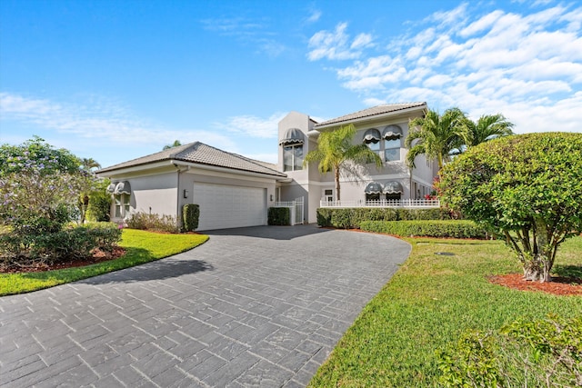 mediterranean / spanish home featuring a garage and a front yard