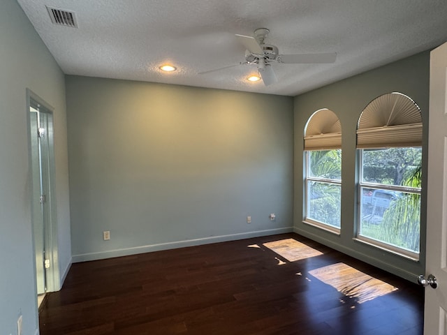 spare room featuring ceiling fan, dark hardwood / wood-style floors, and a textured ceiling