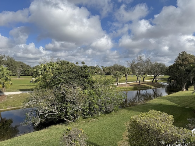 view of home's community with a water view and a yard