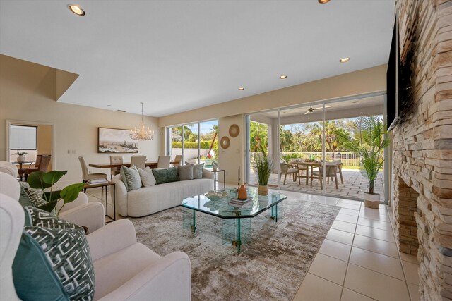 dining room with light tile patterned flooring, a notable chandelier, and a fireplace