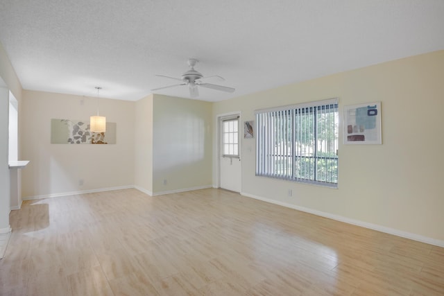 unfurnished room featuring a textured ceiling, light hardwood / wood-style floors, and ceiling fan