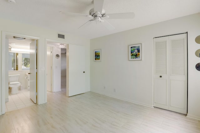 unfurnished bedroom with connected bathroom, a closet, ceiling fan, a textured ceiling, and light hardwood / wood-style flooring