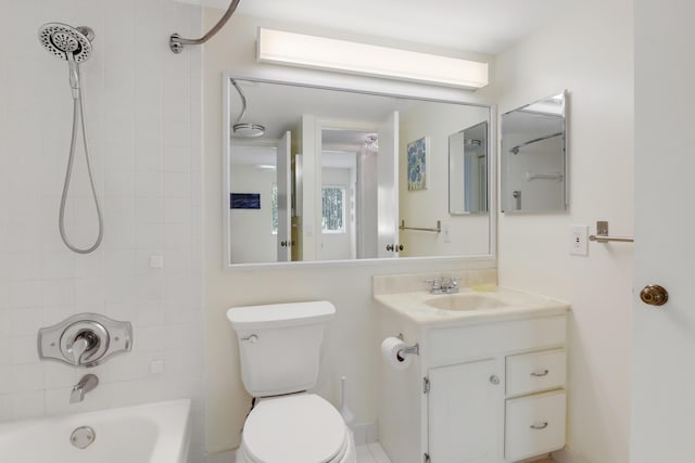 full bathroom featuring tiled shower / bath, vanity, and toilet