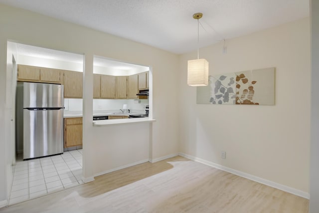 kitchen featuring pendant lighting, sink, light hardwood / wood-style flooring, stainless steel refrigerator, and light brown cabinets