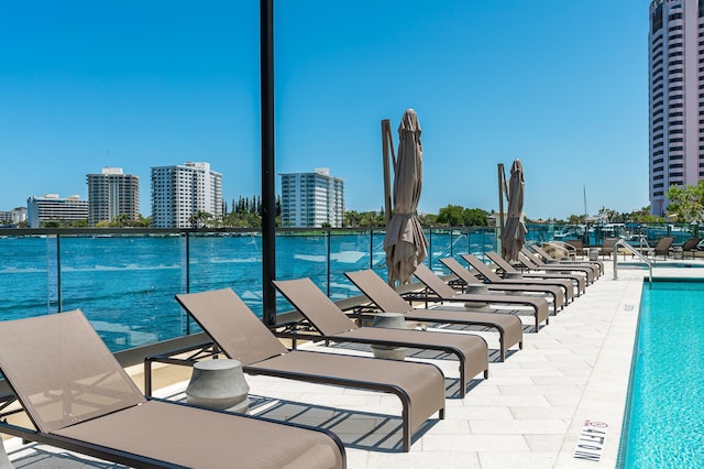 view of pool with a view of city and a water view