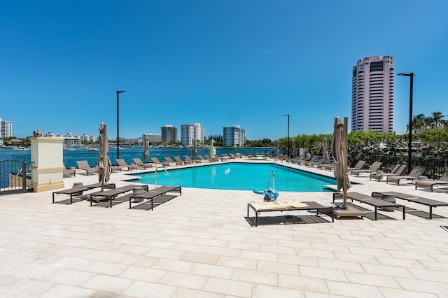 community pool with a view of city and a patio