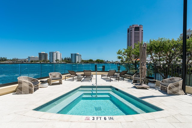 view of pool with a patio area, a city view, and a water view