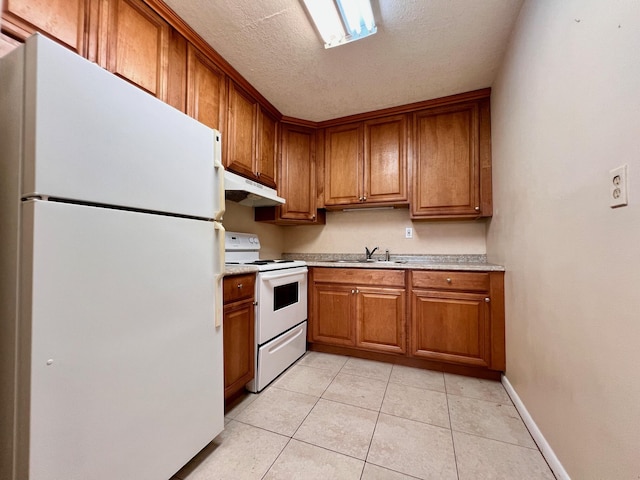 kitchen with sink, light tile patterned floors, a textured ceiling, and white appliances