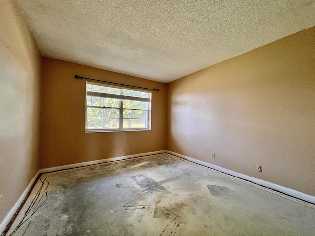 empty room with concrete flooring and a textured ceiling