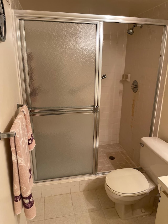 bathroom with vanity, toilet, an enclosed shower, and tile patterned flooring