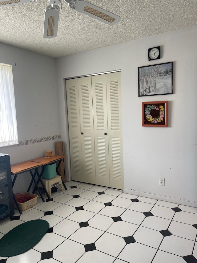 bedroom featuring ceiling fan, a textured ceiling, and a closet