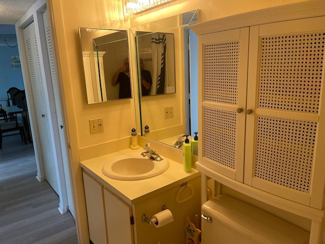 bathroom with vanity, hardwood / wood-style floors, a textured ceiling, and toilet