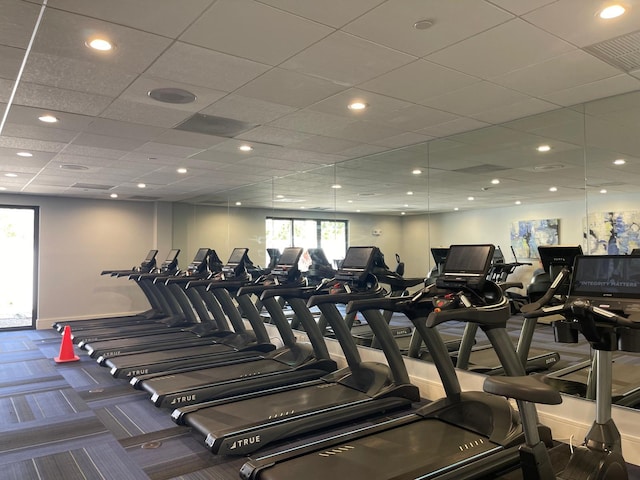 exercise room featuring a drop ceiling and carpet floors