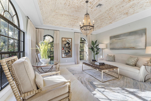 living room featuring crown molding, a notable chandelier, and a tray ceiling