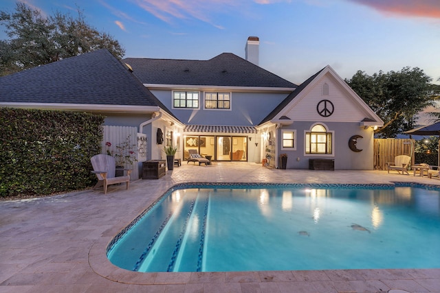 pool at dusk featuring a patio area