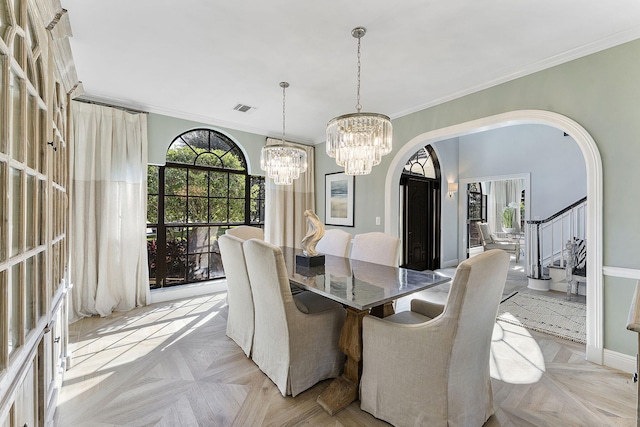 dining room with crown molding, light parquet flooring, and a notable chandelier