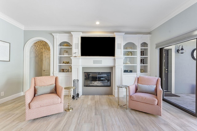 sitting room with ornamental molding and light hardwood / wood-style floors