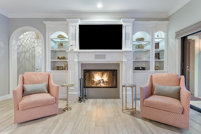 living area with crown molding and light hardwood / wood-style floors