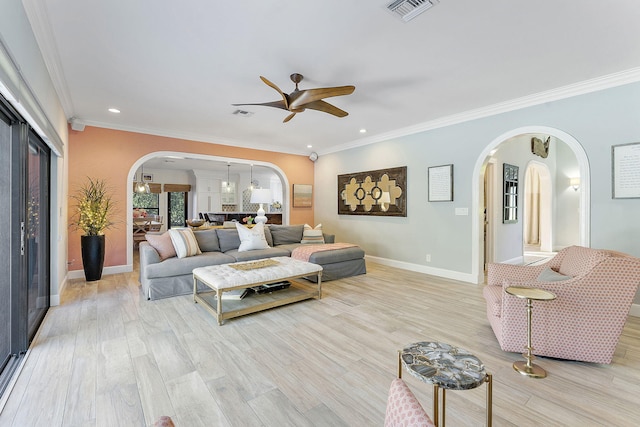 living room with crown molding, ceiling fan with notable chandelier, and light wood-type flooring